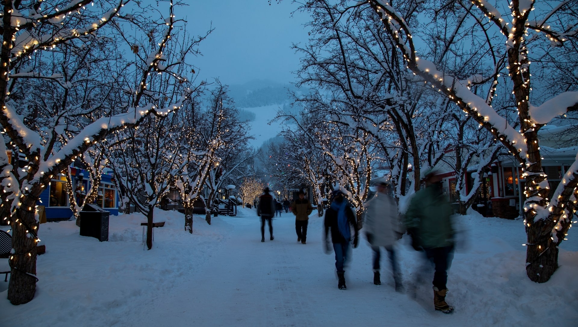 People walking down snowy street with Christmas lights, Aspen, CO
